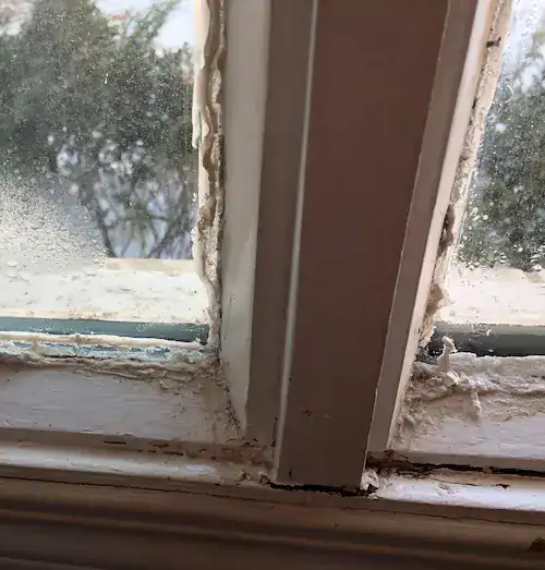Close-up of frosted window with peeling paint