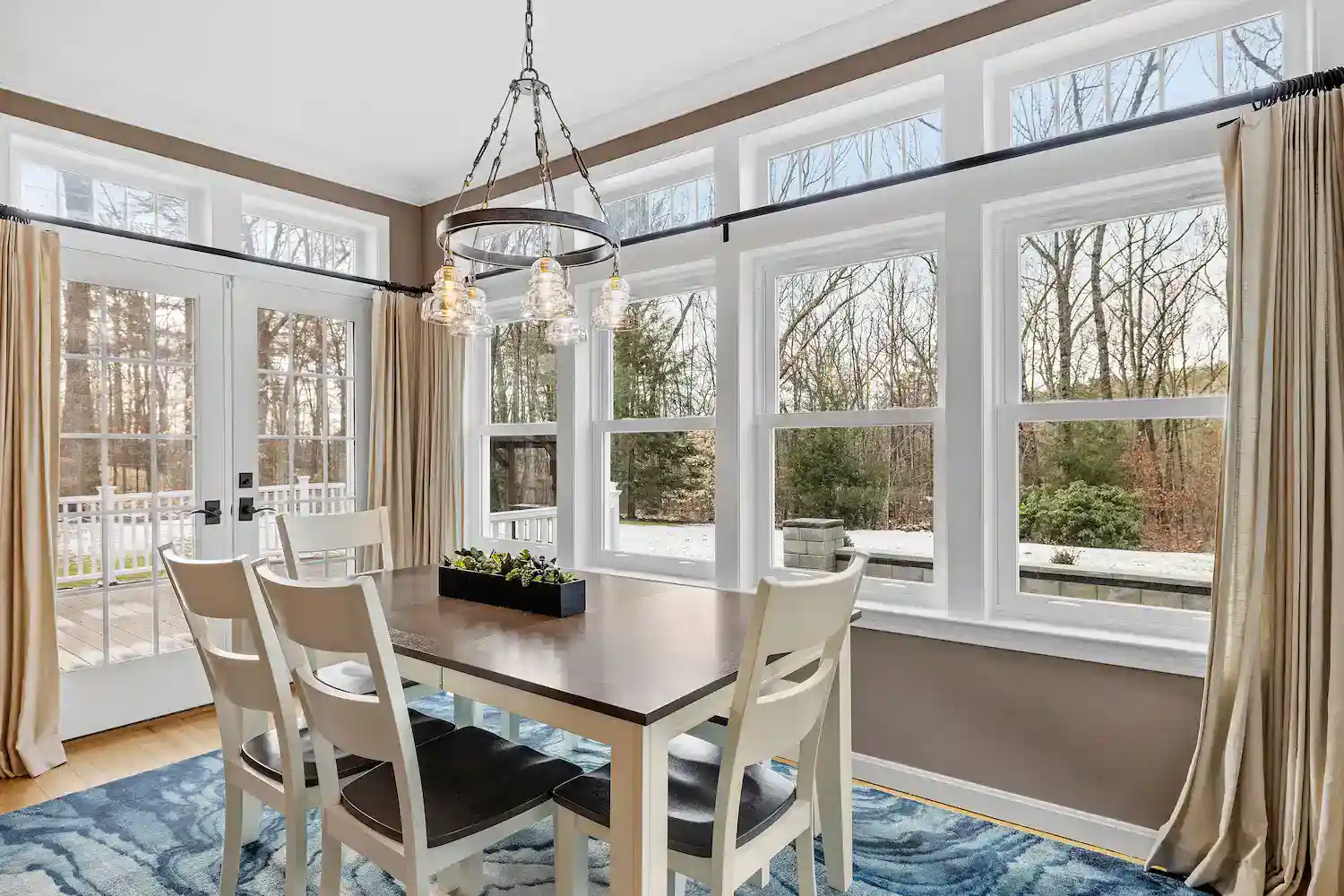 Bright dining room with four double-hung windows and a scenic view.