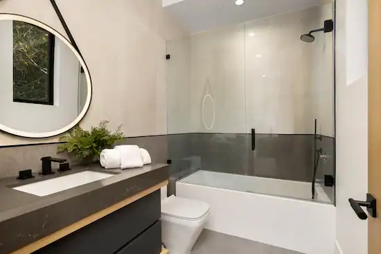 Modern bathroom with a custom frameless shower glass enclosure, an example of the kind of shower enclosures A Pro Windows & Doors can do.